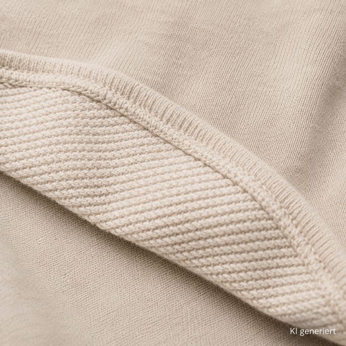 Nahaufnahme einer French-Terry-Stoffstruktur mit sichtbaren weichen Schlingen auf der Innenseite und feiner Strickstruktur.